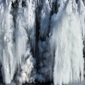 Cachoeira congelada com uma nuvem de pó de diamante - um delicioso fenômeno do inverno